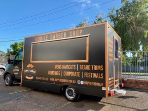 Side view of the Dapper Domain mobile barber shop truck.