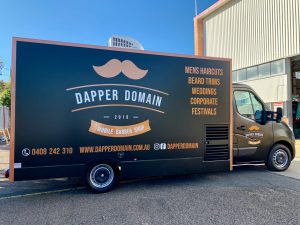 Side view of the Dapper Domain mobile barber shop truck.