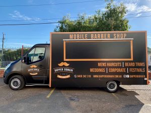 Side view of the Dapper Domain mobile barber shop truck.