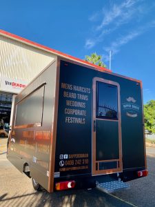 Rear view of the Dapper Domain mobile barber shop truck.