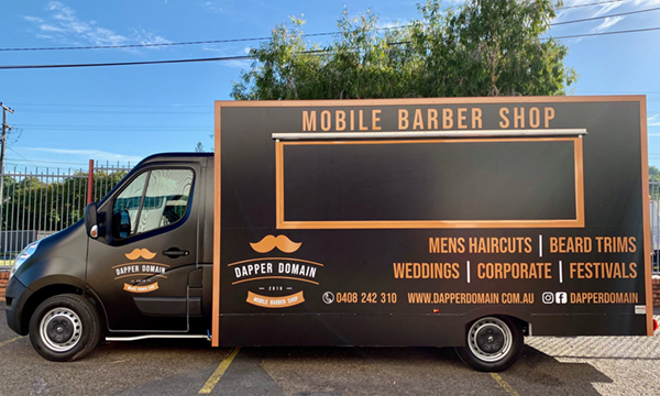 Side view of the Dapper Domain mobile barber shop truck.