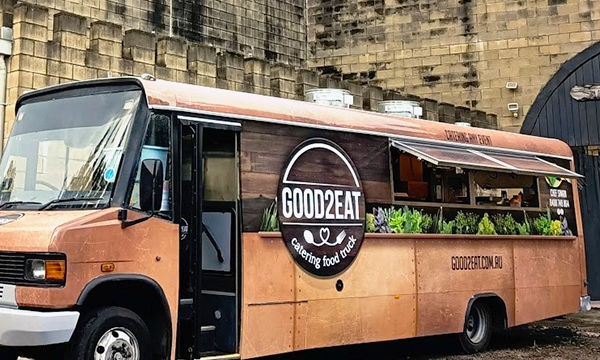 Side view of the Good2Eat Catering bus.